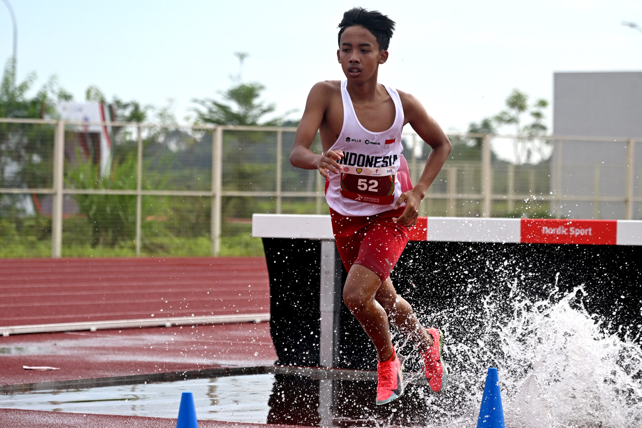Pelari Indonesia Nashat Abdul Kholik melakukan lompatan air pada final lari halang rintang 2000 meter U-18 kejuaraan Atletik Asia Tenggara U-18 & U-20 di Stadion Madya Atletik Kawasan Sport Centre Sumut, Kabupaten Deliserdang, Provinsi Sumatera Utara, Selasa (18/11/2025). Nashat Abdul Kholik meraih medali emas dengan catatan Waktu 6 menit 17 detik mengalahkan pelari Singapura Ahmad Zubayr dengan catatan Waktu 6 menit 46 detik, dan pelari Kamboja Korn Singha dengan catatan Waktu 7 menit 15 detik. Diskominfo Sumut / Fahmi Aulia
